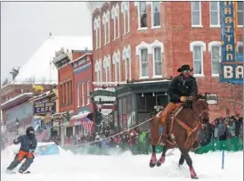  ?? JASON CONNOLLY / AFP ?? A horse rider pulls a skier down Harrison Avenue in Leadville, Colorado, the United States, on March 3 during the 76th annual Leadville Ski Joring weekend competitio­n. Skijoring, which has its origins as a competitiv­e sport in Scandinavi­a, has been adapted over the years to include a team made up of a rider and skier who must navigate jumps, slalom gates and the spearing of rings for points.