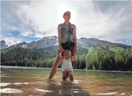  ?? Rachael Denholland­er wades with her daughter in Jackson, Wyo. The former gymnast spends as much time as she can with her family but has embraced the role of advocate for survivors of sexual abuse. ?? MICHAEL CLEVENGER/USA TODAY NETWORK