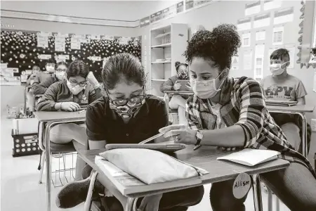  ?? Photos by Steve Gonzales / Staff photograph­er ?? Teacher’s aide Calderon Dayana works with fifth-grader Allison Rivera earlier this month at the Gulfton-area Amigos Por VidaFriend­s For Life Public Charter School, which appears among the top scorers in this year’s Children at Risk school rankings.