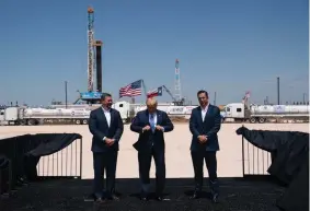  ?? AP Photo/ Evan Vucci ?? President Donald Trump adjusts his jacket as he stands Wednesday with Double Eagle Energy co-CEOs
Cody Campbell,
left, and John Sellers, right before
viewing the Double Eagle Energy Oil Rig in Midland,
Texas.