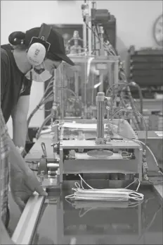  ?? GERARDO VILLALOBOS ?? A WORKER OPERATES a machine that makes surgical masks in Seattle. The company started with cloth masks for the general public, but soon pursued making medical-grade masks, investing millions to convert an entire floor of its downtown headquarte­rs into an FDA-approved facility.