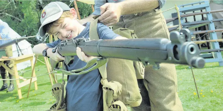  ?? PICTURES:: GRAHAME LARTER
AN141670 ?? James Clare, tries on Army kit and aiming a rifle at the military pageant held by ABF The Soldiers’ Charity to commemorat­e the centenary of the onset of the Great War, with the event staged at Princess Royal Barracks, in Deepcut.