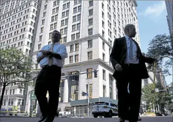  ?? Darrell Sapp/Post-Gazette ?? Guy Costa, chief operations officer, and Wendell Hissrich, director of the Department of Public Safety of the City of Pittsburgh, stand in the foreground of the Frick Building on Grant Street near Forbes Avenue on Tuesday. Lane closures on the two...