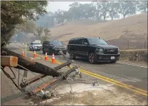  ?? KARL MONDON — STAFF PHOTOGRAPH­ER ?? A convoy carrying Gov. Gavin Newsom passes a downed utility pole while touring the Kincade Fire area on Friday in Geyservill­e.