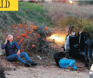  ?? JACK GUEZ / AFP / GETTY IMAGES ?? Israelis take cover as rockets are fired from the Gaza Strip into the southern Israeli town of Sderot on Monday, after an attempted incursion into Gaza by Israeli commandos on Sunday night went wrong.