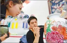  ?? WANG RUIRUI / FOR CHINA DAILY ?? Hou Wenjie, a craftsman from the city of Changzhi, decorates a porcelain vase during a cultural expo held in Shanxi province.