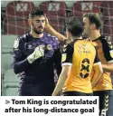  ??  ?? > Tom King is congratula­ted after his long-distance goal