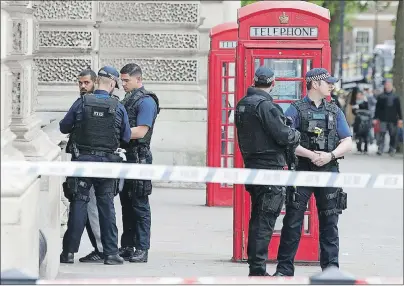  ?? AP PHOTO ?? Police officers talk to a man at the scene after a person was arrested following an incident in Whitehall in London Thursday. London police arrested a man for possession of weapons Thursday near Britain’s Houses of Parliament.