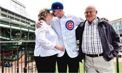  ?? MATT MARTON/AP ?? Ross kisses his mother, Jackie, as his father, David, looks on Monday outside Wrigley Field.