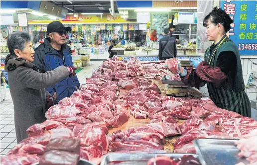  ??  ?? BEEFING UP SUPPLIES: Customers buying meat at a food market in eastern China’s Shandong province. Cloned meat may be available in the near future.