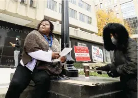  ?? JOHN HART/ WISCONSIN STATE JOURNAL VIA AP ?? Madison, Wis. residents Theola Carter, left, and Carrie Braxton fill out their ballots on the first day of the state’s in-person absentee voting window for the Nov. 3 election outside the city’s City-County Building last week.