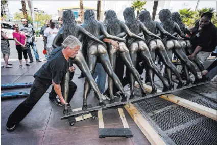  ?? JEFF SCHEID/ LAS VEGAS REVIEW-JOURNAL ?? Dane Ironmonger helps load the “Crazy Girls” statue Monday at the Riviera hotel-casino. The statue is going on tour in the valley.