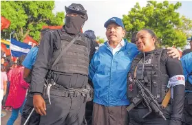  ?? CRISTOBAL VENEGAS/ASSOCIATED PRESS ?? Nicaraguan police have their picture taken with President Daniel Ortega in Masaya, Nicaragua, on July 13.