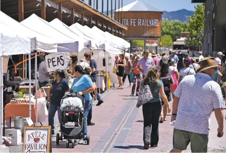  ?? PHOTOS BY CLYDE MUELLER/THE NEW MEXICAN ?? Shoppers browse the Santa Fe Farmers Market on Tuesday at the Railyard. Next week, Wednesday Eve @ The Railyard begins its summer run with music, entertainm­ent and other activities.