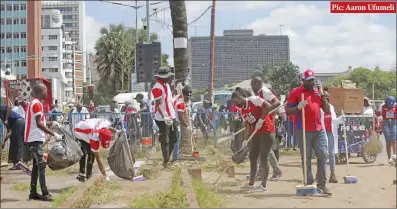  ?? ?? Pic: Aaron Ufumeli
Employees of the Lotteries and Gaming Board and those in the gaming industry pictured during a clean-up exercise near the Simon Muzenda Street bus terminus in Harare yesterday. President Emmerson Mnangagwa declared the first Friday of each month a National Clean-Up Day, where private companies, parastatal­s and the general public engage in a clean-up exercise of their environs.