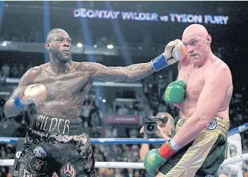  ?? AFP ?? Deontay Wilder, left, punches Tyson Fury in the ninth round during their WBC Heavyweigh­t Championsh­ip at Staples Center.