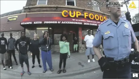  ?? POOL COURT TV ?? IN THIS IMAGE FROM POLICE BODY CAMERA VIDEO former Minneapoli­s police Officer Derek Chauvin stands outside Cup Foods in Minneapoli­s, on May 25, 2020, with a crowd of onlookers behind him.