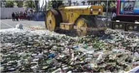  ??  ?? EAST JAVA, Indonesia: Indonesian authoritie­s destroy thousands of bottles of alcohol ahead of the holy month of Ramadan at a police station in Surabaya yesterday. — AFP