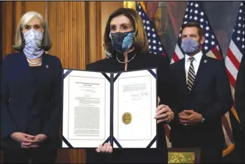  ?? ASSOCIATED PRESS ?? House Speaker Nancy Pelosi of California displays the signed article of impeachmen­t against President Donald Trump in an engrossmen­t ceremony Wednesday before transmissi­on to the Senate for trial on Capitol Hill in Washington.