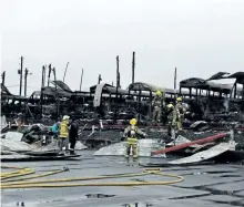  ?? MICHAEL RUBINKAM/THE ASSOCIATED PRESS ?? Firefighte­rs clear wreckage from a school bus depot in South Whitehall, Pa., that was destroyed by fire on Friday.
