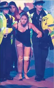  ?? Rex Features ?? POLICE OFFICERS help one of the wounded outside the Manchester Arena in England. At least 59 people were transporte­d to hospitals by ambulance.