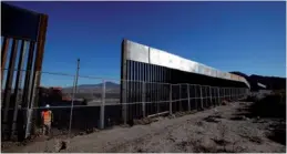  ?? JOSE LUIS GONZALEZ / REUTERS ?? A worker stands next to a newly built section of the US-Mexico border fence at Sunland Park, US opposite the Mexican border city of Ciudad Juarez, Mexico on Wednesday. Picture taken from the Mexico side of the US-Mexico border.