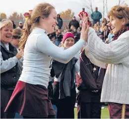  ?? COURANT FILE PHOTO ?? Granby field hockey coach Sandy Wickman Mason congratula­tes captain Katherine Bossler after Granby won the Class S championsh­ip in 2007 as Sandy’s sister and co-coach Jodi Bascetta (far left) smiles widely at Wethersfie­ld High.