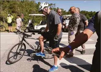  ?? Manuel Balce Ceneta / Associated Press ?? President Joe Biden gets back on his bike after falling when he tried to get off his bike at the end of a ride to greet a crowd at Gordons Pond in Rehoboth Beach, Del., Saturday. “I’m good,” he told reporters after U.S. Secret Service agents quickly helped him up. “I got my foot caught” in the toe cages. The president quickly collected himself and spent several minutes chatting with people who had gathered to watch him bike. Biden did not need medical attention and is “fine,” according to a White House statement.