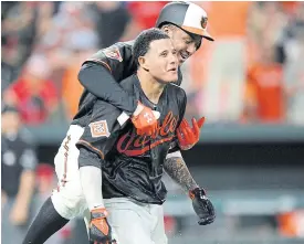  ??  ?? The Orioles’ Manny Machado, right, celebrates with Jonathan Schoop after hitting the game winning grand slam in the ninth inning against the Angels.