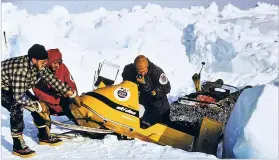  ??  ?? Members of an expedition that traveled to the North Pole in 1968 push a snowmobile out of broken ice.