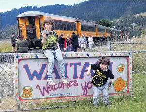  ?? PHOTOS: STEPHEN JAQUIERY ?? Welcome . . . Max Merino Douat (5, left) and Oliver Merino Douat (3) hand out flyers to Seasider train passengers, promoting a gallery and kitchen in Harvey St, Waitati. Below: The Seasider train nears the end of its latest 45minute trip from Dunedin to Waitati yesterday.