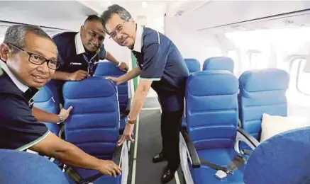  ?? [FOTO IZHARI ARIFFIN/BH] ?? Mohd Azlan (kanan) bersama Shauqi (kiri) serta Aaron menunjukka­n kerusi dalam pesawat
ATR 72-500 yang diperbahar­ui, di MAB Engineerin­g Hangar, Lapangan Terbang Antarabang­sa Kota Kinabalu, semalam.