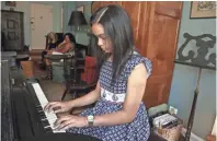  ?? BEBETO MATTHEWS/AP ?? Anmy Paulino Collado plays the piano as her music teacher, Julie Wegener, background left, and mom, Andolina Collado, listen in New York. Private music lessons are beyond the reach of many families, and even for families with means, there are tricky...