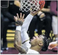  ?? Arkansas Democrat-Gazette/MITCHELL PE MASILUN ?? UALR junior guard Rayjon Tucker (left) puts up a shot under the basket during the Trojans’ victory over Texas-Arlington on Thursday night in Little Rock.