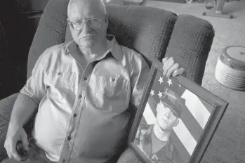  ?? THOMAS PEIPERT/AP ?? Donn Edmunds, a 25-year U.S. Army veteran, sits for a portrait Sept 1 in his living room in Cheyenne, Wyo. Edmunds’ son, Army Ranger Spc. Jonn Edmunds, was among the first U.S. casualties in the Afghanista­n war.