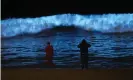  ??  ?? Spectators watch biolumines­cent plankton light up the shoreline as they churn in the waves at Dockweiler state beach. Photograph: Mark J Terrill/AP