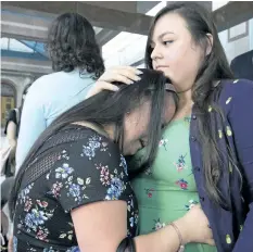  ?? STAN BEHAL/TORONTO SUN ?? Francie Munoz cries on her sister Yasmin’s shoulder, as they prepare to leave Toronto Police headquarte­rs.