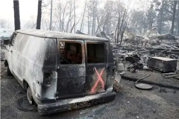  ??  ?? A van marked by search crews is seen in the aftermath of the Camp Fire in Paradise, California. — Reuters photo