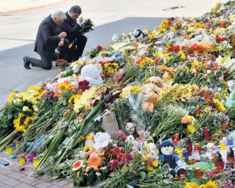  ?? Sergei Supinsky / AFP / Getty Images ?? Dutch Ambassador to Ukraine Kees Klompenhou­wer (left) and Ukrainian President Petro Poroshenko at a flower-laying ceremony at the Netherland­s Embassy in Kiev on Monday.