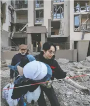  ?? GLEB GARANICH / REUTERS ?? Residents leave their pulverized apartment building on Friday in Kyiv.