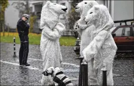  ?? MARTIN MEISSNER / ASSOCIATED PRESS ?? Protesters dressed as polar bears are watched by a police officer as they talk on a backstreet after a demonstrat­ion outside the COP 23 Fiji U.N. Climate Change Conference in Bonn, Germany, on Saturday.