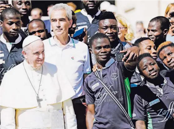  ?? AF ?? El papa Francisco posó para selfis junto a los integrante­s de un equipo de ‘rugby’ de migrantes a los que saludó ayer en plaza de San Pedro.