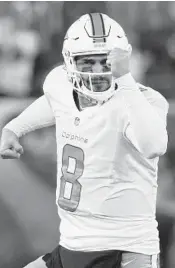  ?? AL BELLO/GETTY IMAGES ?? Dolphins quarterbac­k Matt Moore celebrates after throwing a 52-yard touchdown pass against the jets.