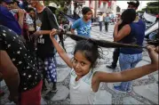  ??  ?? Seven-year-old Evelin Flores of Honduras plays with her hair as she stands in the plaza where her family was camping out in Tapanatepe­c, Oaxaca state, Mexico.