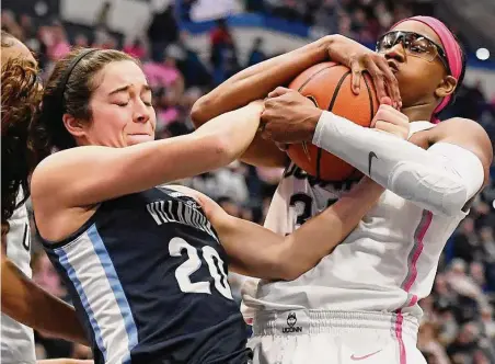  ?? Jessica Hill / Associated Press ?? Villanova’s Maddy Siegrist, left, and UConn’s Ayanna Patterson, right, fight for the ball in the first half on Sunday in Hartford.