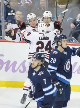  ?? JOHN WOODS/AP ?? The Blackhawks’ David Kampf (from left), Dominik Kahun and John Hayden celebrate Hayden’s goal against the Jets during the first period Thursday.