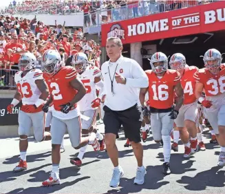  ?? AARON DOSTER, USA TODAY SPORTS ?? Coach Urban Meyer, leading the Buckeyes onto the field before their spring game in April, is 50-4 in four seasons as Ohio State coach.