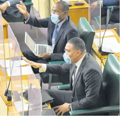  ?? IAN ALLEN/ PHOTOGRAPH­ER ?? Prime Minister Andrew Holness (foreground) leads the banging of desks on the government benches while jeering Opposition Leader Mark Golding during his Budget Debate presentati­on on Tuesday.