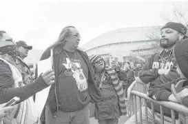  ?? Marie D. De Jesús / Houston Chronicle ?? Juan Manias, center, a member of the Carrizo Comecrudo Tribe of Texas, tries to explain his position on the importance of protecting Native American territory to a skeptic downtown on Saturday.