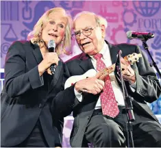  ??  ?? Warren Buffett plays a ukelele with actress Glenn Close at a meeting of his shareholde­rs